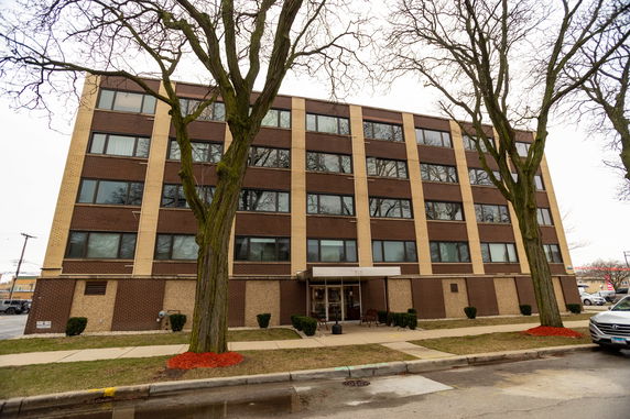 Front view of a multi-story residential building with a brick facade.
