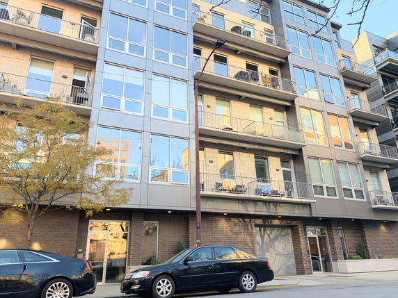 Front view of a multi-story apartment building with balconies.