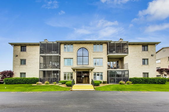 Front view of a three-story building with balconies.