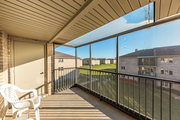 View from a balcony overlooking apartment buildings and grassy area.
