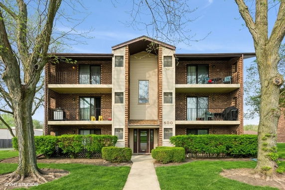 Front view of a three-story apartment building with balconies.
