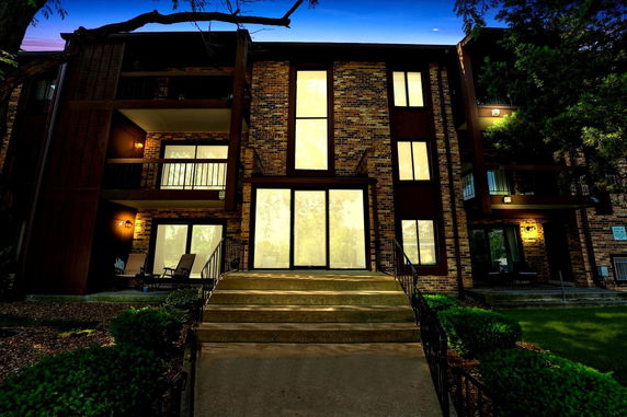 Front view of a multi-story brick building with balconies and large windows.