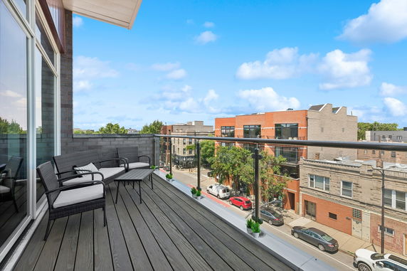 Balcony view overlooking urban street and buildings.