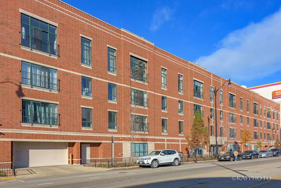 Front view of a multi-story brick building with parking area.