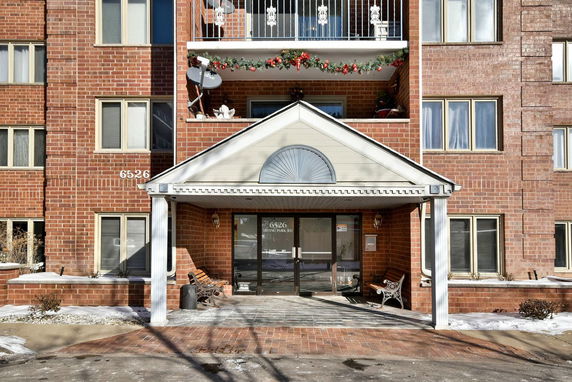 Front view of a multi-story brick building with a covered entrance.