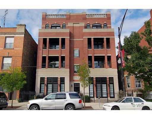 Front view of a multi-story brick apartment building with balconies.