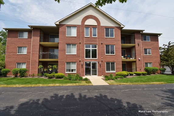 Front view of a three-story brick apartment building.