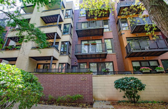 Front view of a multi-story apartment building with balconies.