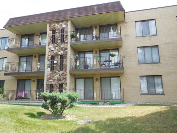 Front view of a three-story apartment building with balconies.