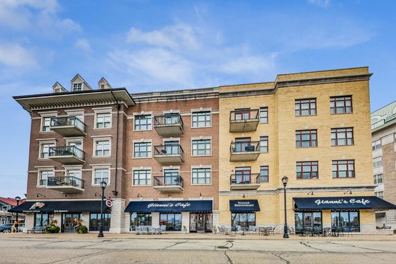 Front view of a multi-story building with balconies and storefronts.