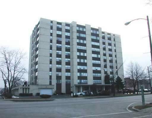 Front view of a multi-story apartment building with symmetrical design and large windows.
