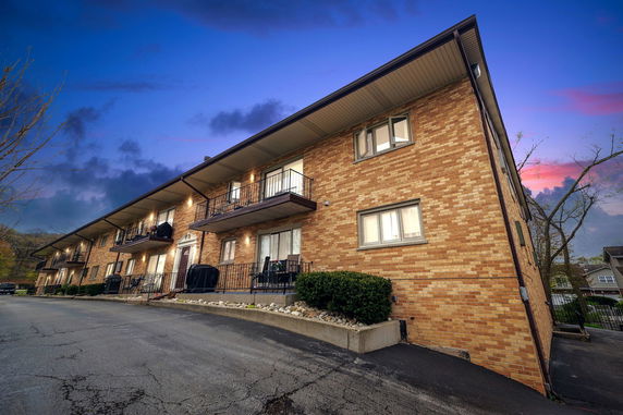 Front view of a multi-story brick building with balconies.