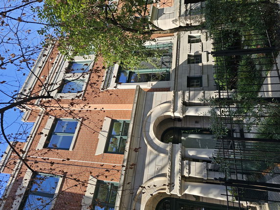 Front view of a multi-story brick building with arched entrance.
