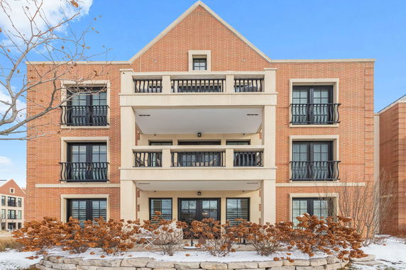 Front view of a multi-story brick building with balconies.
