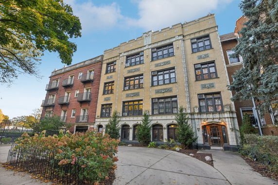 Front view of a multi-story apartment building with decorative detailing.