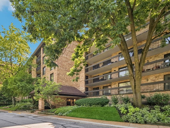 Front view of a multi-story brick apartment building with balconies.