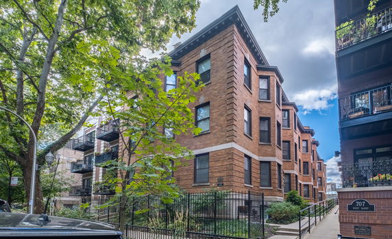 Front view of a multi-story brick apartment building.