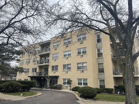 Front view of a multi-story apartment building with balconies.
