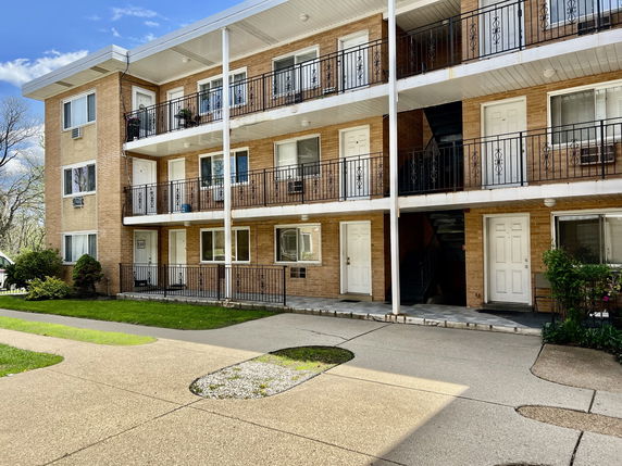 Front view of a multi-story apartment building with balconies.