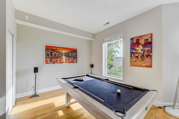 Interior room with a pool table and colorful paintings on the walls.