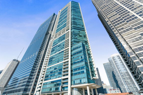 Front view of a tall modern glass skyscraper.
