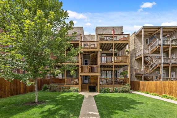 Rear view of a multi-story building with wooden balconies.