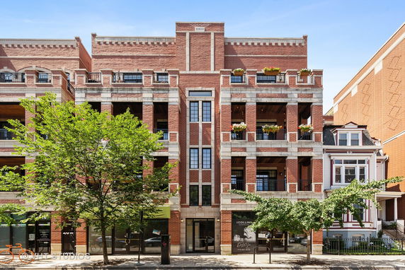 Front view of a multi-story brick building with balconies.