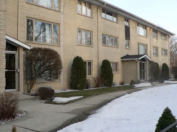 Front view of a multi-story apartment building with brick exterior.