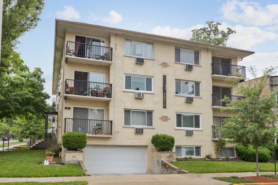Front view of a multi-story apartment building with balconies.