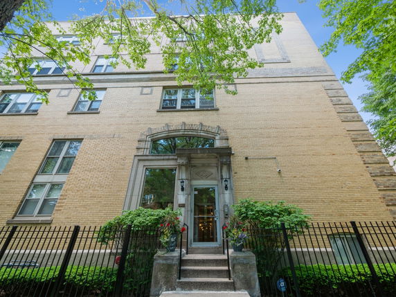 Front view of a multi-story brick building with a decorative entrance.