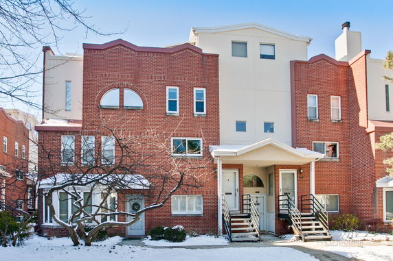 Front view of a multi-story brick house with multiple entrances.