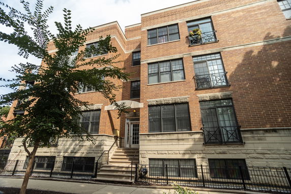Front view of a multi-story brick building with large windows.