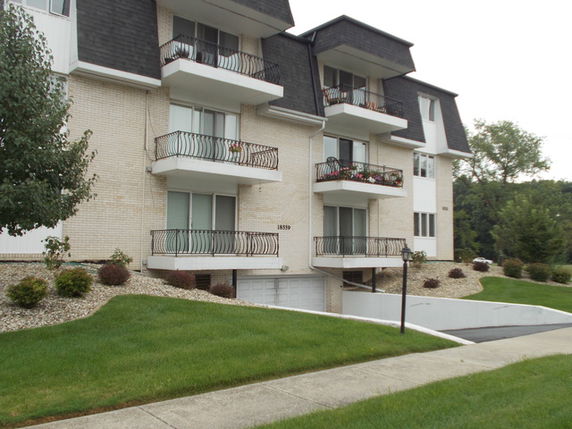 Front view of a multi-story residential building with multiple balconies.
