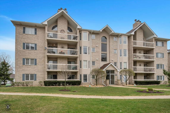 Front view of a multi-story apartment building with balconies.