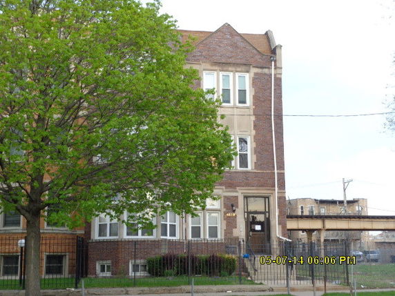 Front view of a multi-story brick building with several windows.