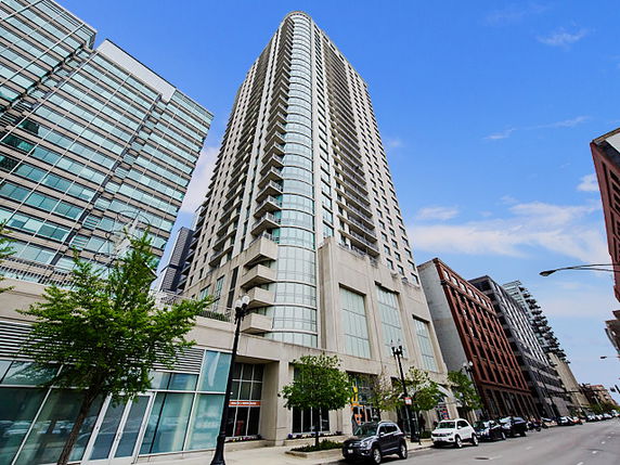 Front view of a high-rise residential building with large windows and multiple balconies.