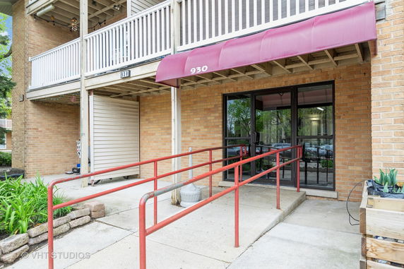 Front view of a building entrance with a red canopy and ramp.