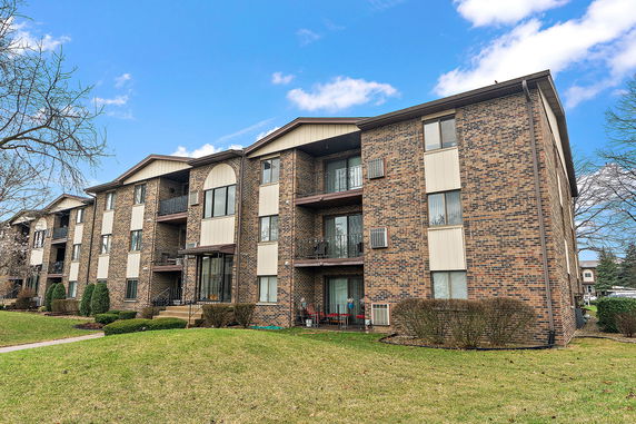 Front view of a multi-story brick apartment building.