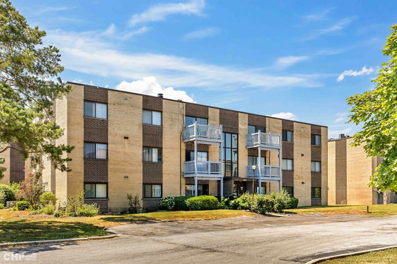 Front view of a multi-story apartment building with balconies.