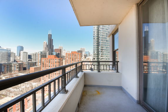 View from a balcony overlooking a cityscape with tall buildings.