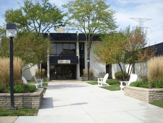 Front view of a two-story building with a black exterior and large windows.