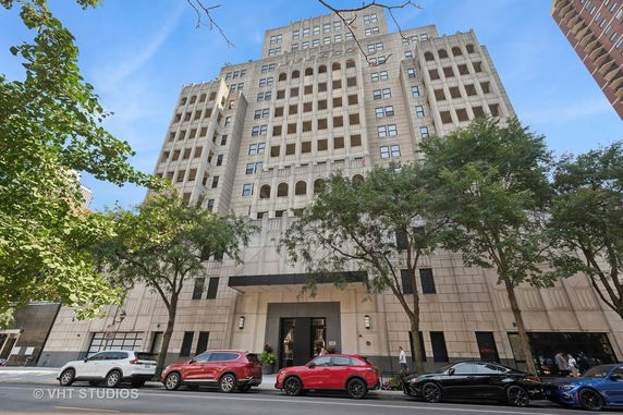 Front view of a multi-story building with a symmetrical facade and arched windows.