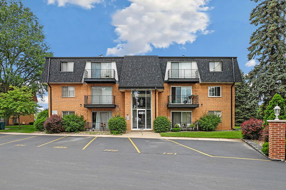 Front view of a three-story apartment building with balconies.