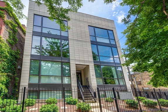Front view of a modern multi-story building with large glass windows.