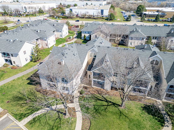 Aerial view of multiple residential buildings with gray roofs.