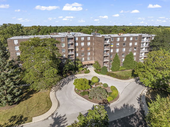 Front view of a multi-story apartment building with a circular driveway.