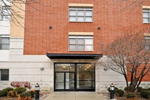 Front view of a multi-story building entrance with brick facade.