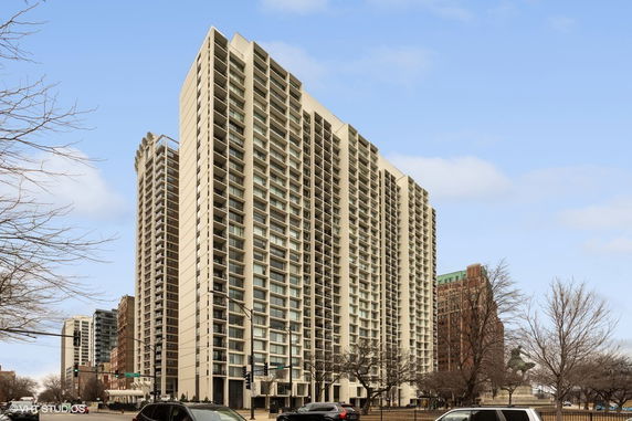 Front view of a tall apartment building with multiple balconies.