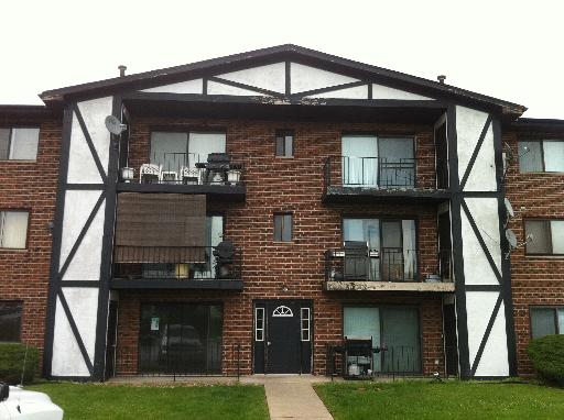 Front view of a multi-story apartment building with balconies.
