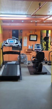 Indoor gym area with exercise equipment including a treadmill and stationary bike.